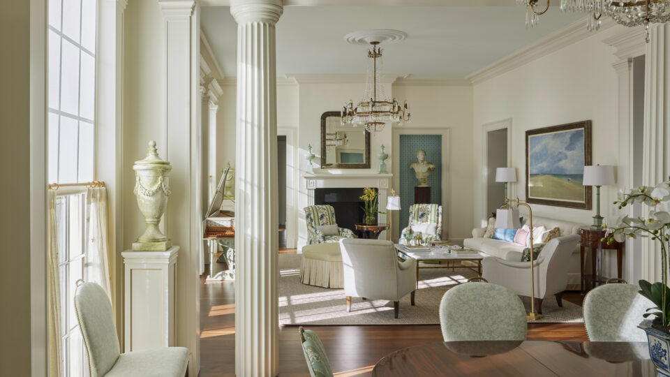 Elegant living room with classic decor, white furniture, and large windows for natural light.