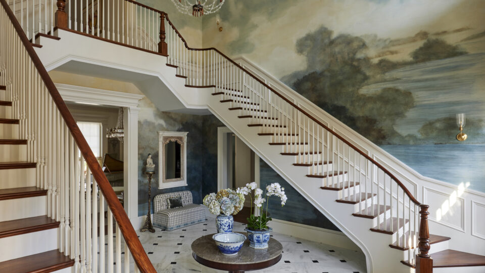 Elegant staircase with mural wall art in a luxurious interior.